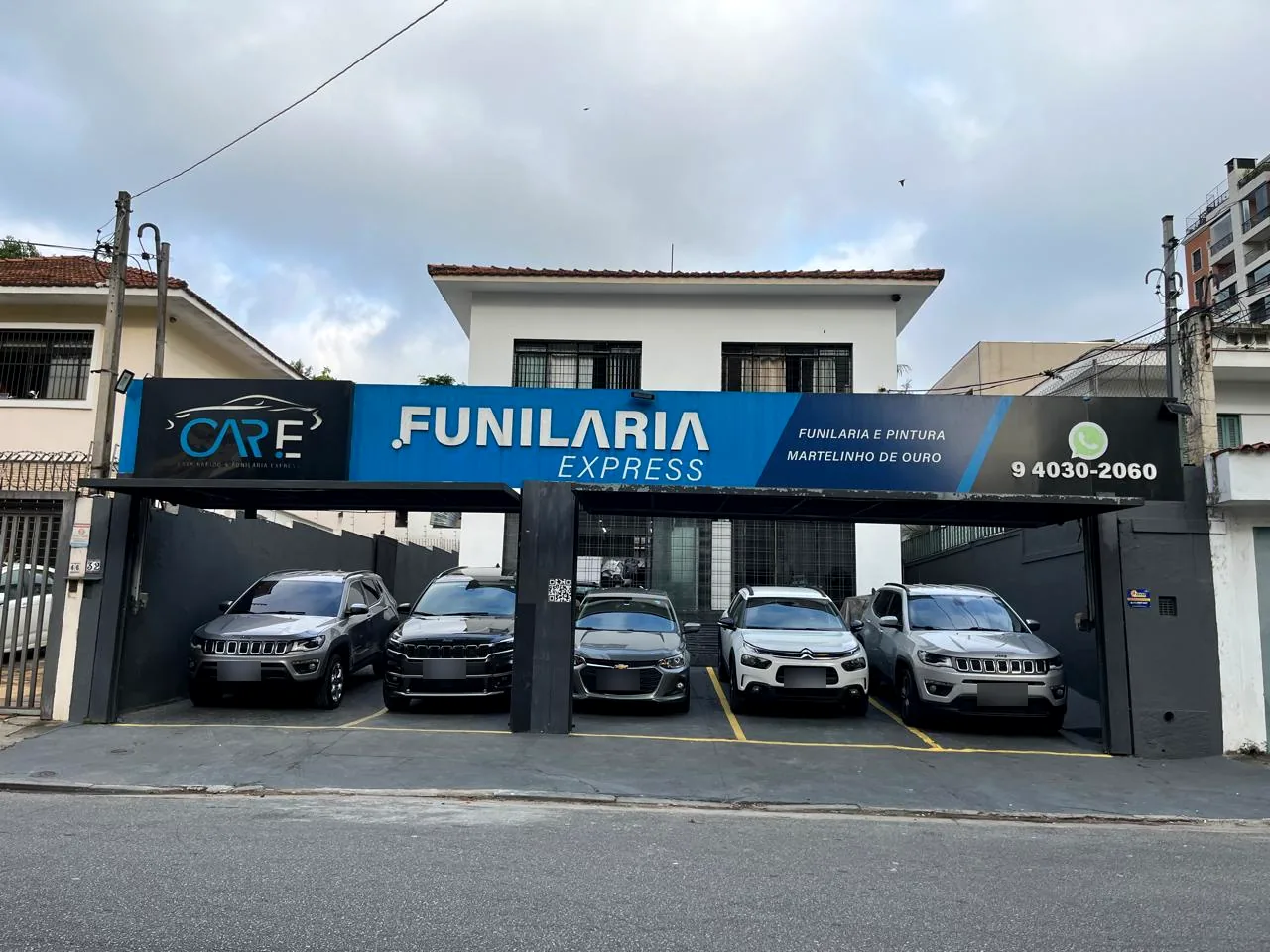 Fachada da Funilaria Express da Care, com carros estacionados
