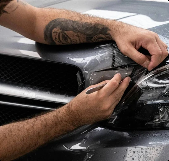 Técnico da Care Automotive trabalhando no acabamento do farol de um veículo