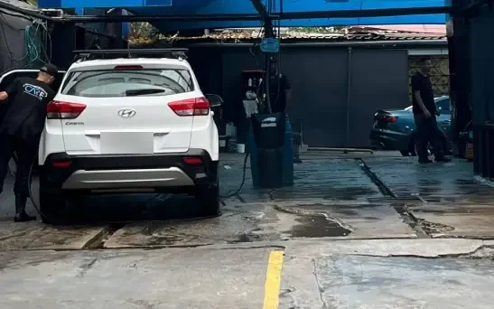 Box de lavagem da Care Automotive com um carro branco em atendimento